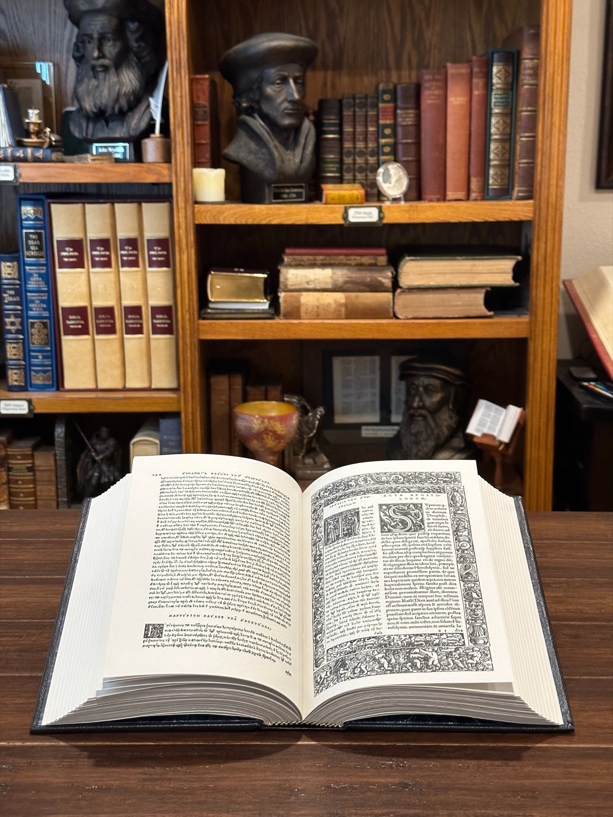 The completed 1522 Erasmus New Testament book opened on a desk with a library in the background
