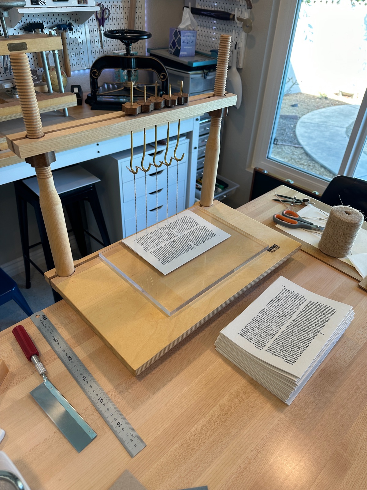 stacks of completed signatures sitting in front of a sewing frame