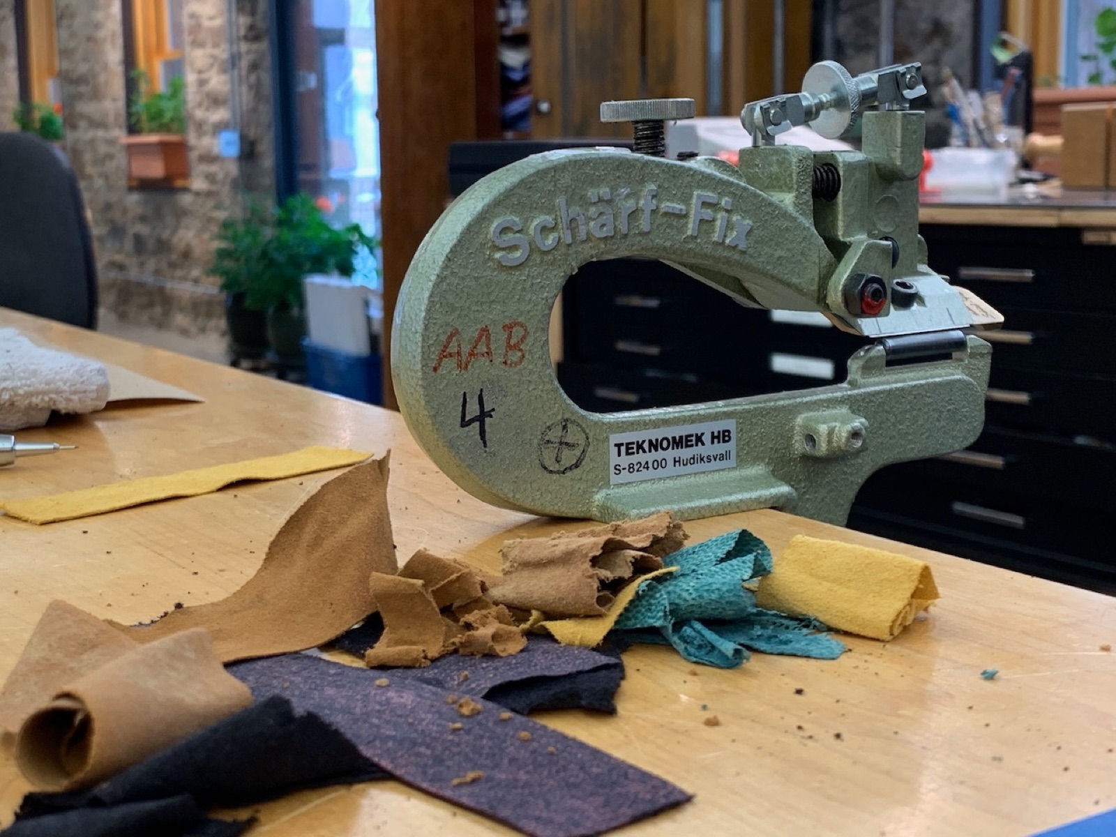 leather scraps in the foreground and a sharfix paring device in the background