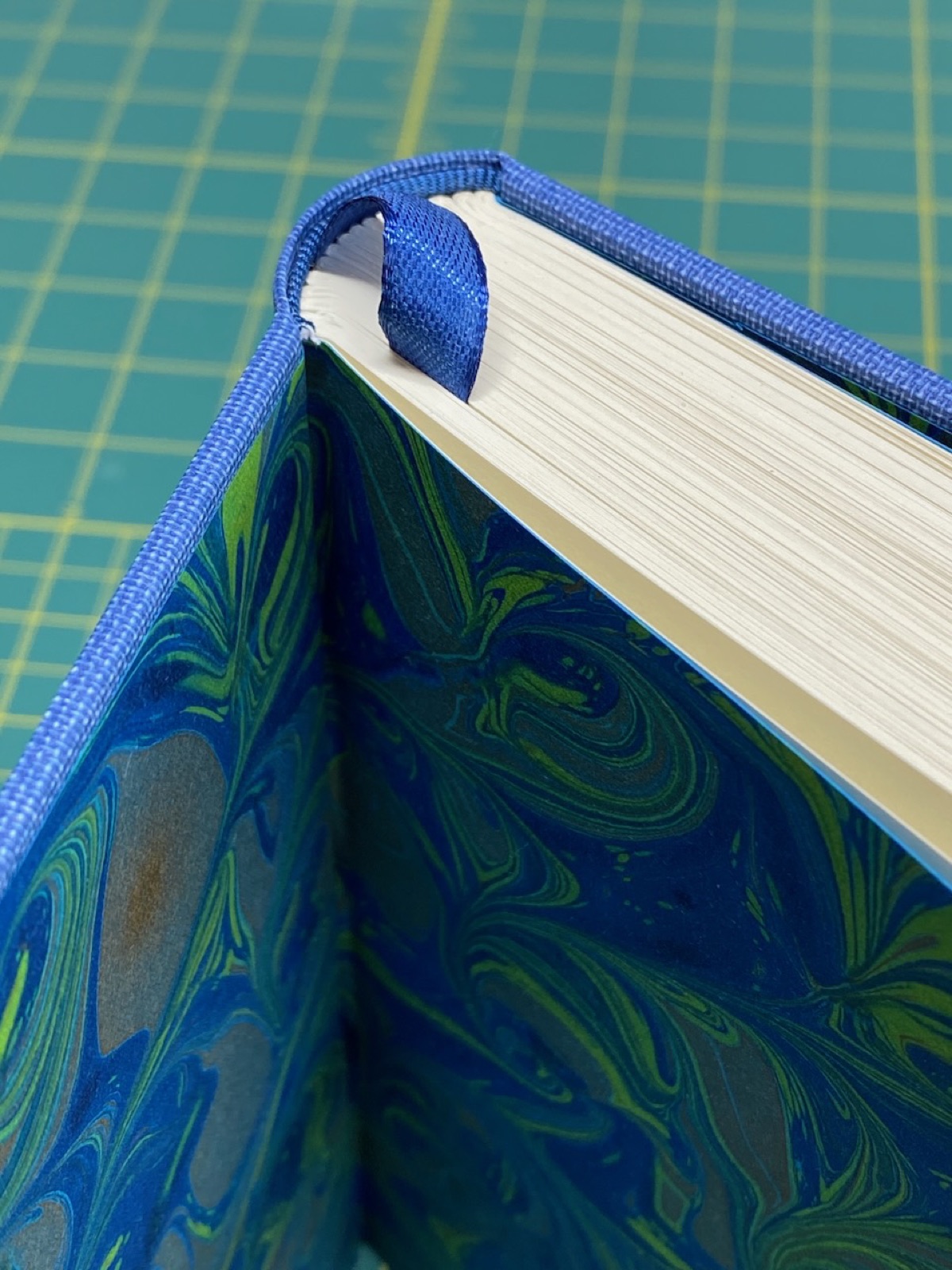 Corner of the blue binding showing marbled endpaper.