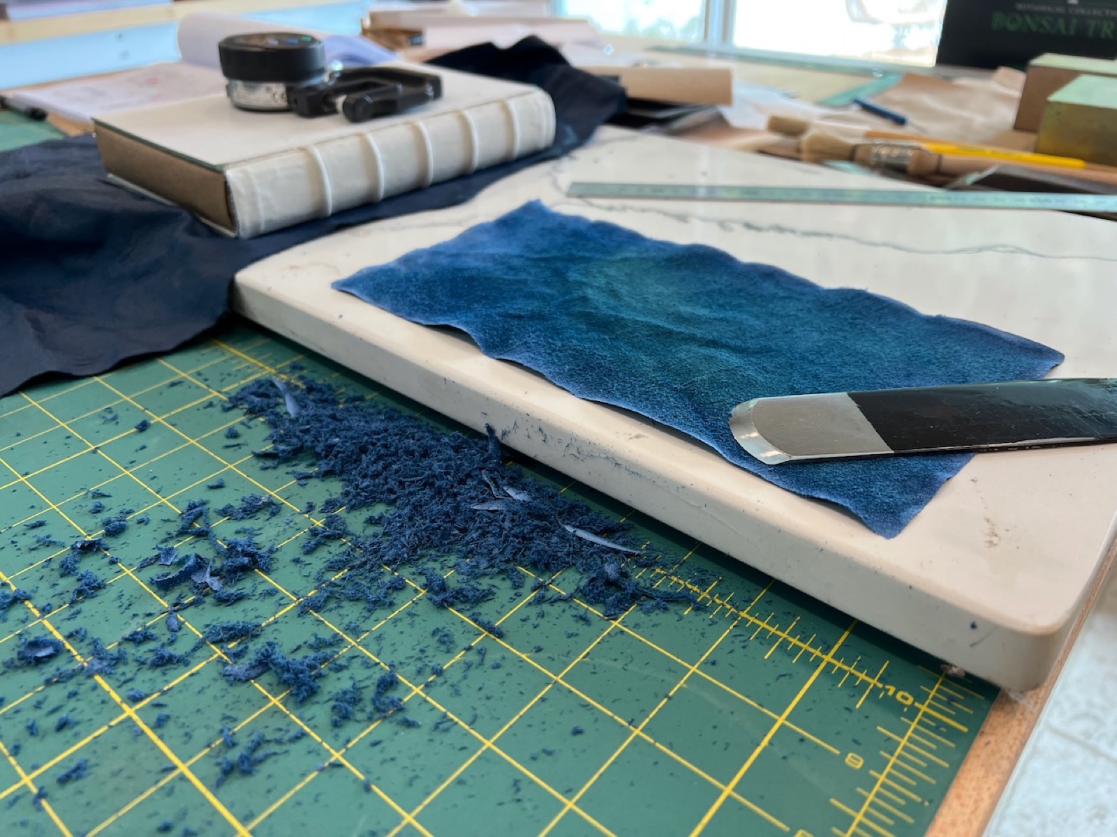 suede side of blue leather sitting on marble slab showing the paring of the leather