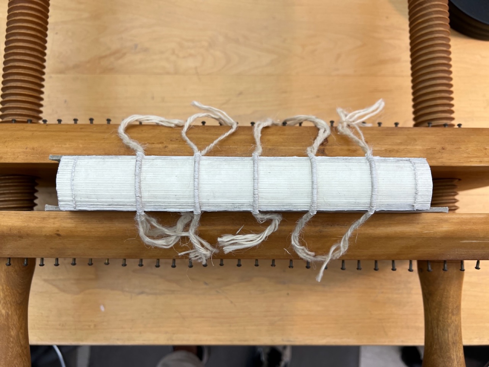 book in a press showing spine is prepped for the leather