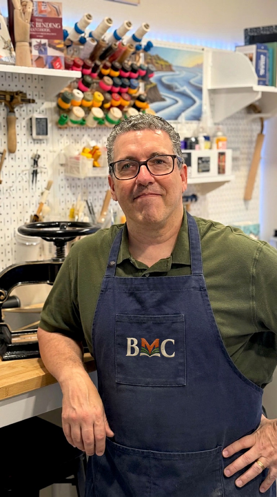 Bob Bender in his workshop wearing a navy BMC apron.