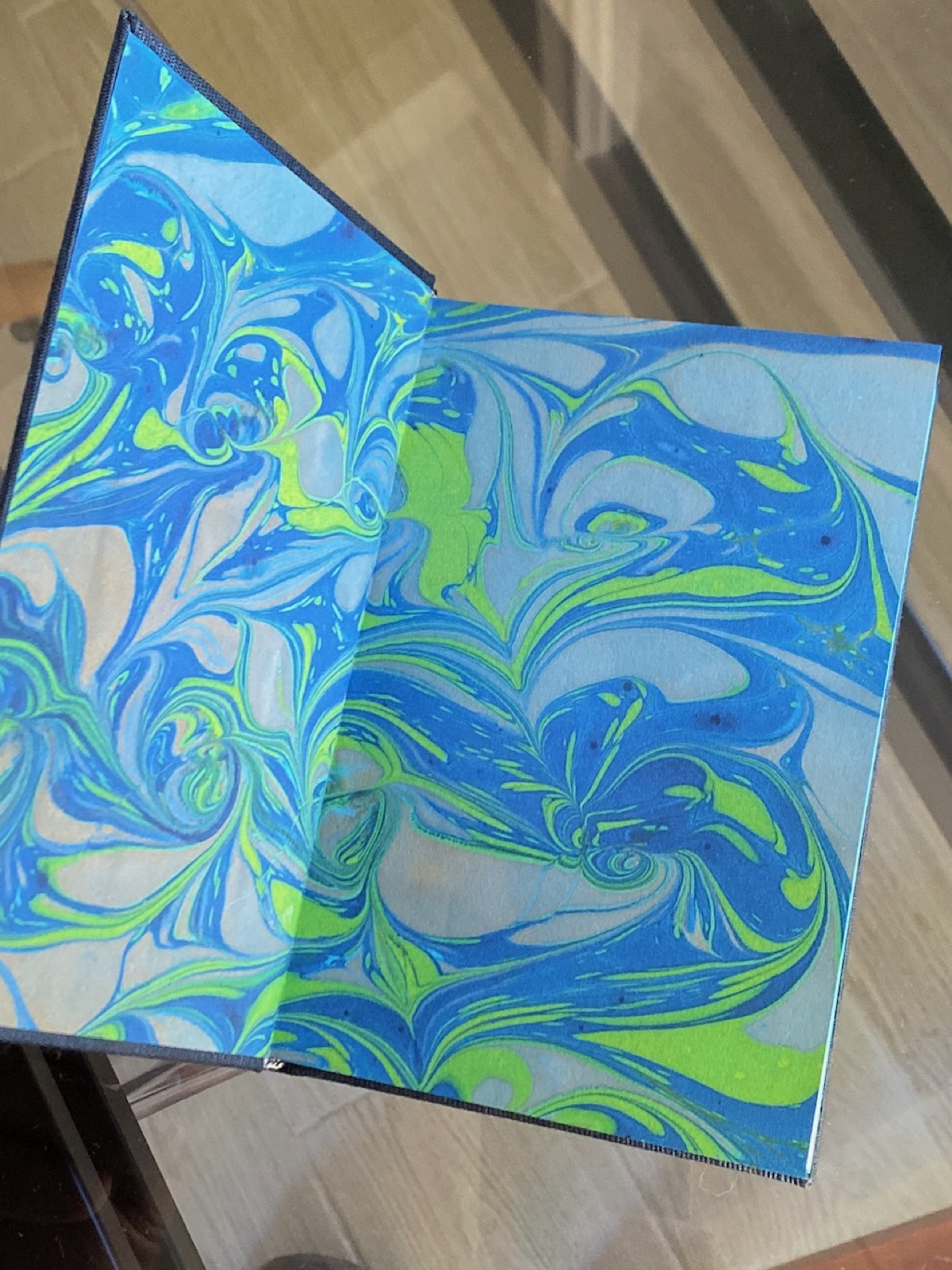 Open view of the vivid blue and green marbled endpapers.