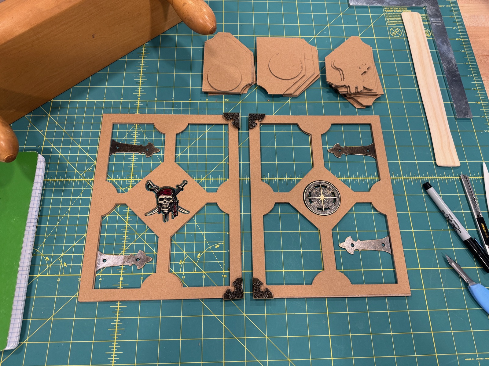 template of wood and metal embellishments sitting on green mat