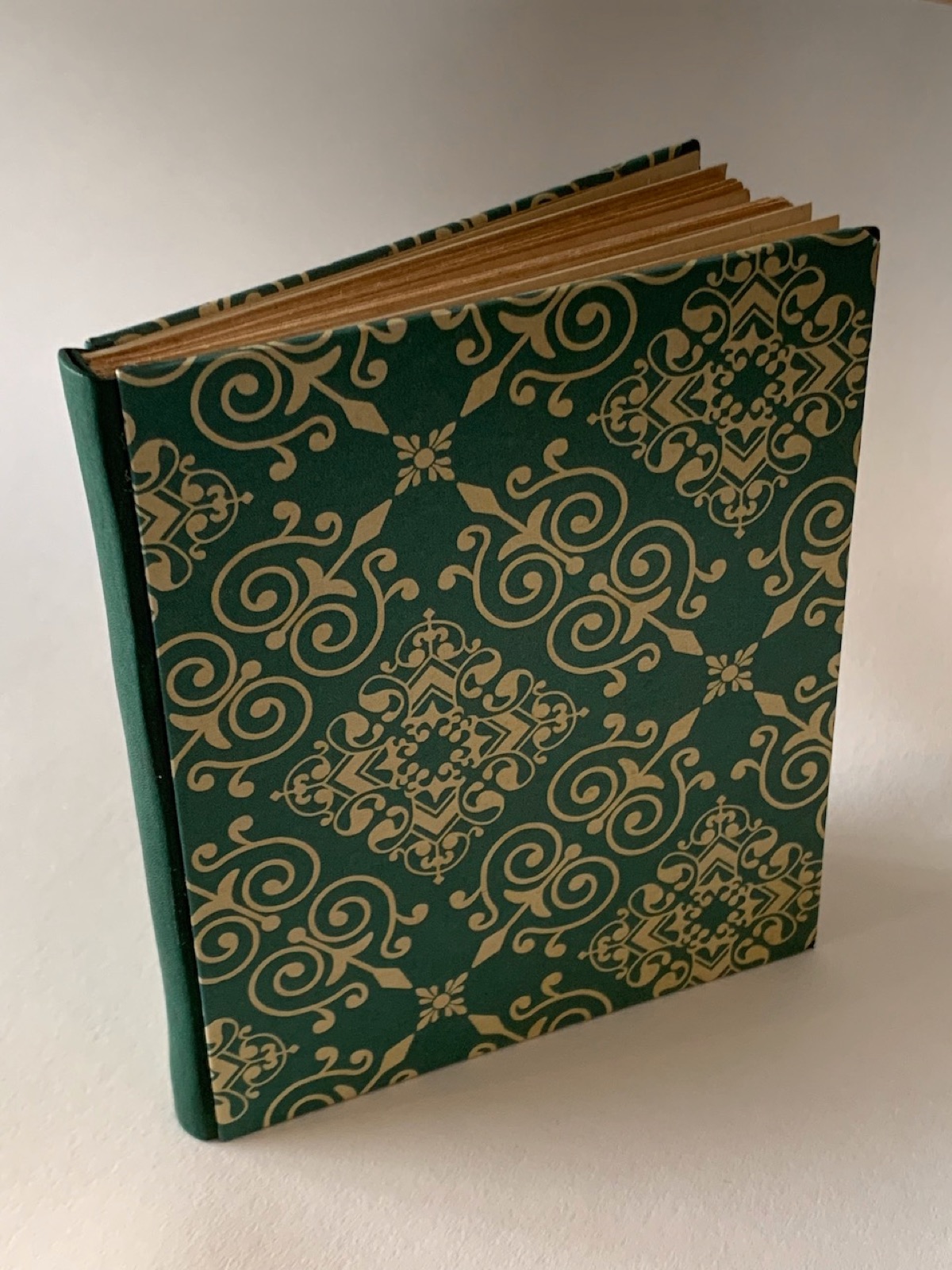 A newly rebound small primer book with 3 piece binding of green leather and green decorative paper