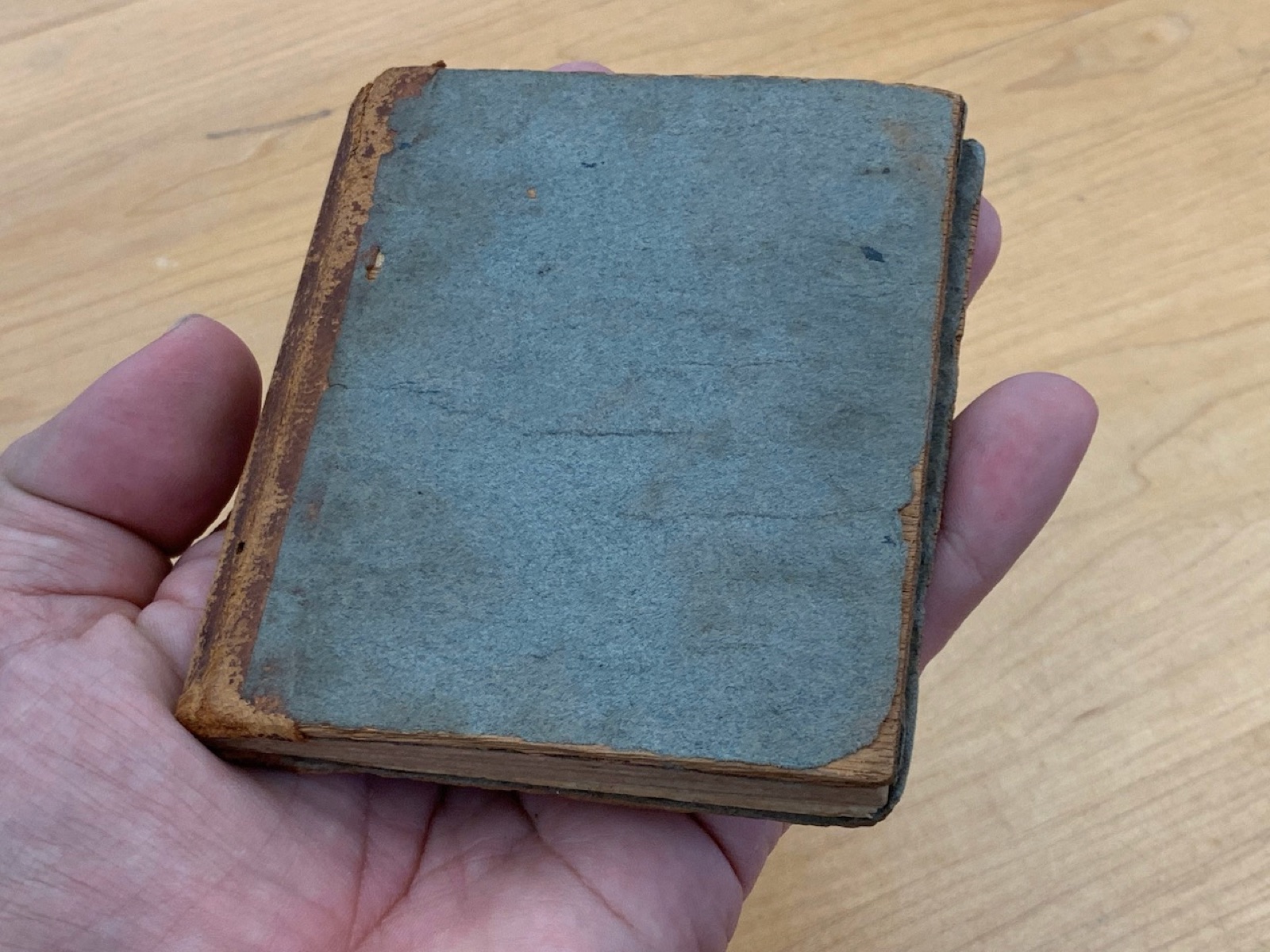 original antique deteriorating binding of a book on a persons hand
