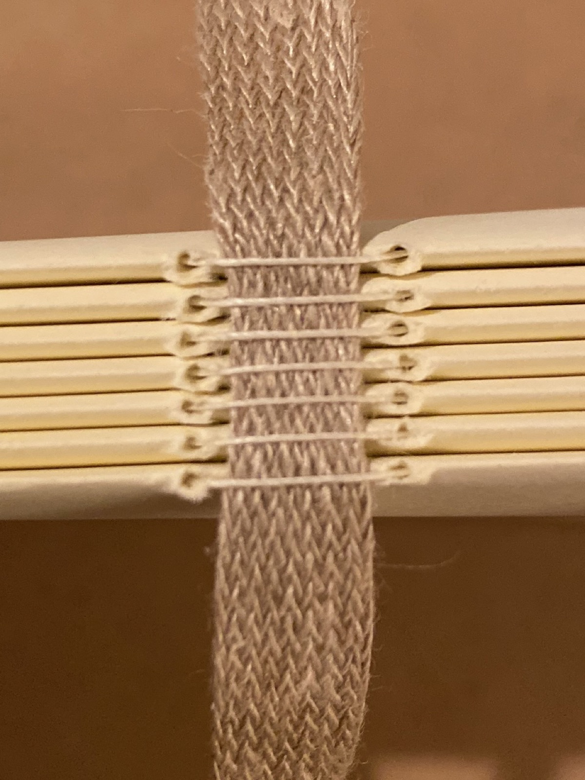 Close view of folded signature spines sewn over a woven tape support.