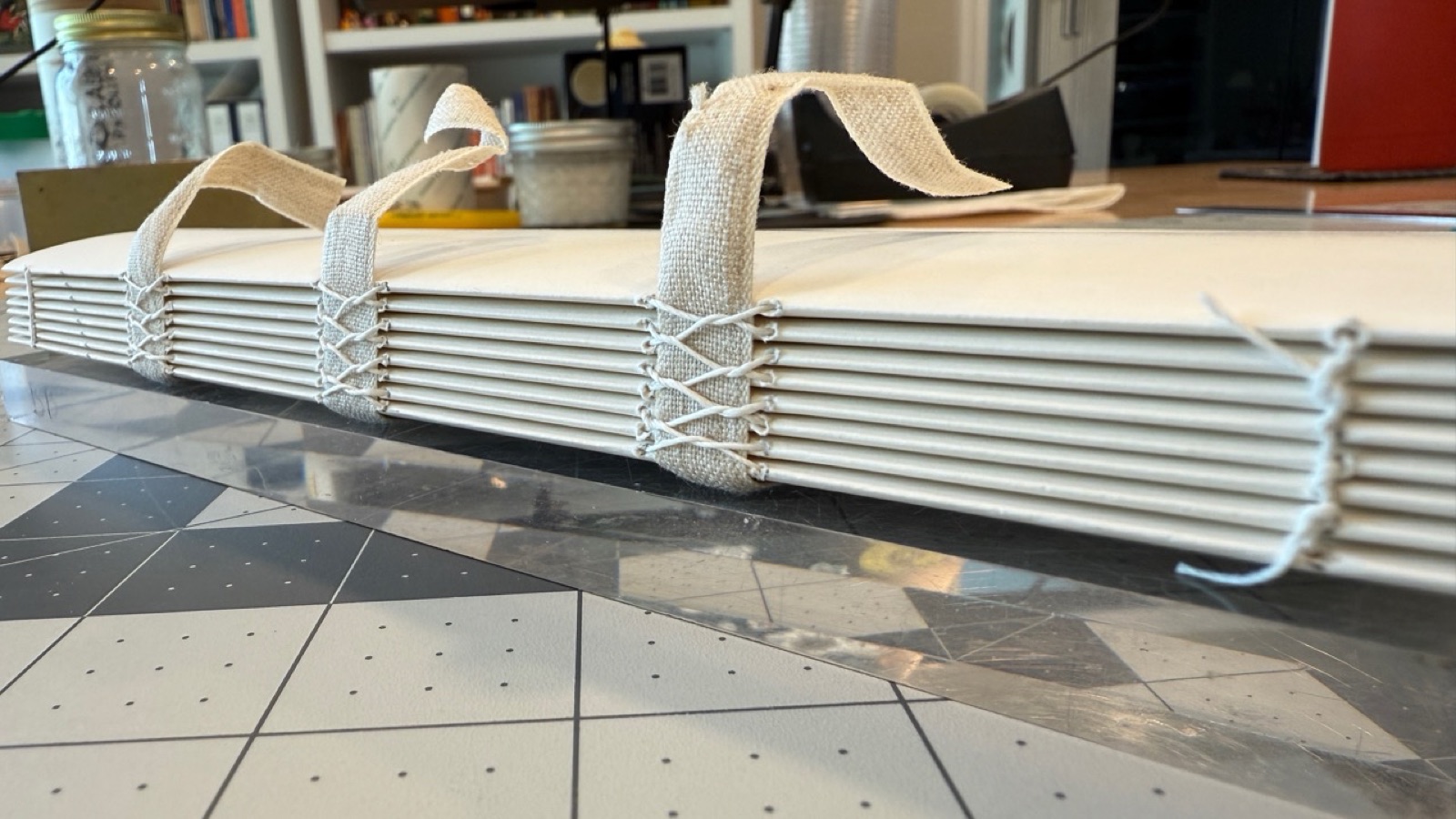 Sewn signatures and linen tape securing the text block for bookbinding.