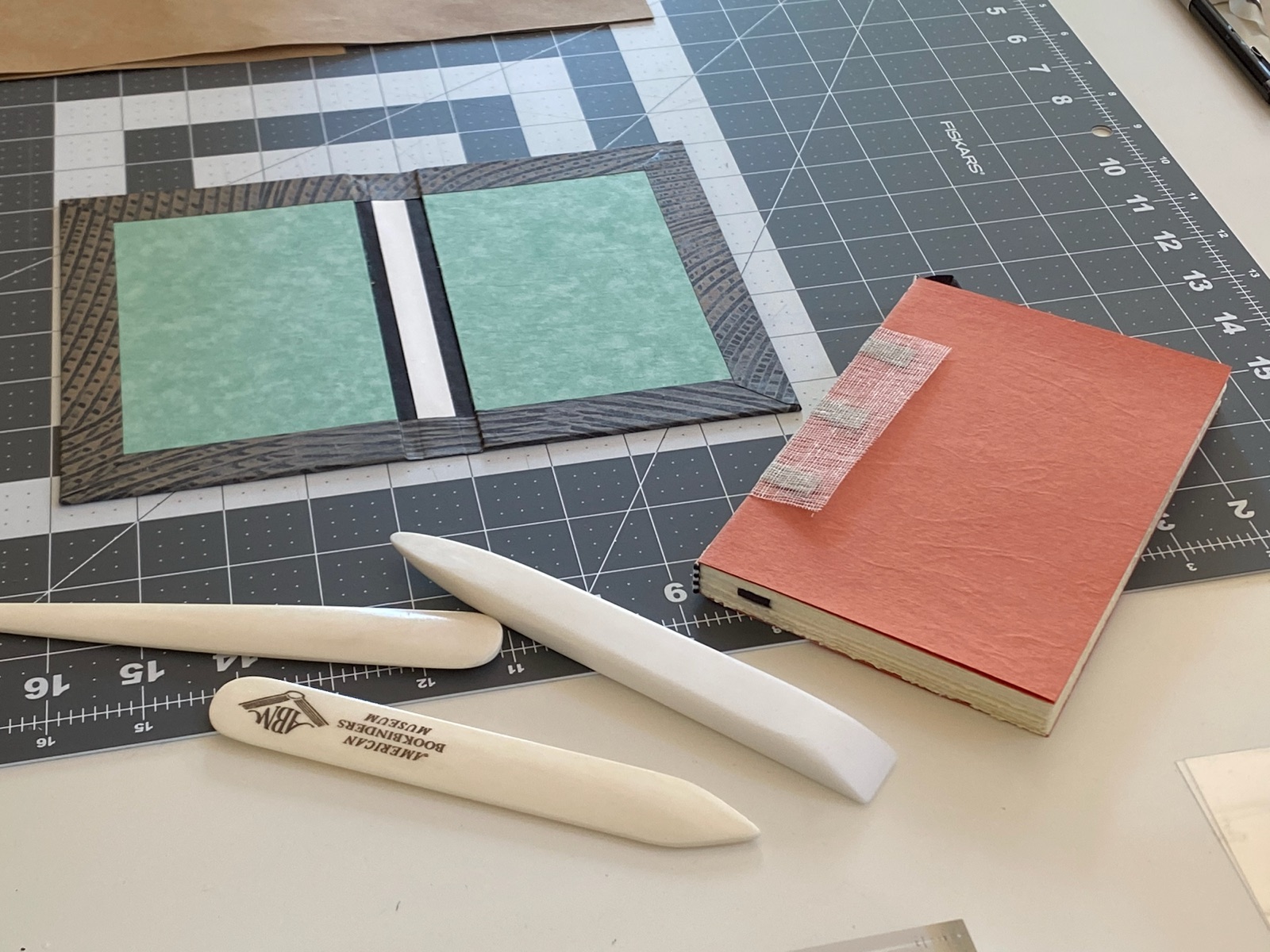 a case binding cover and text block sitting on a cutting mat