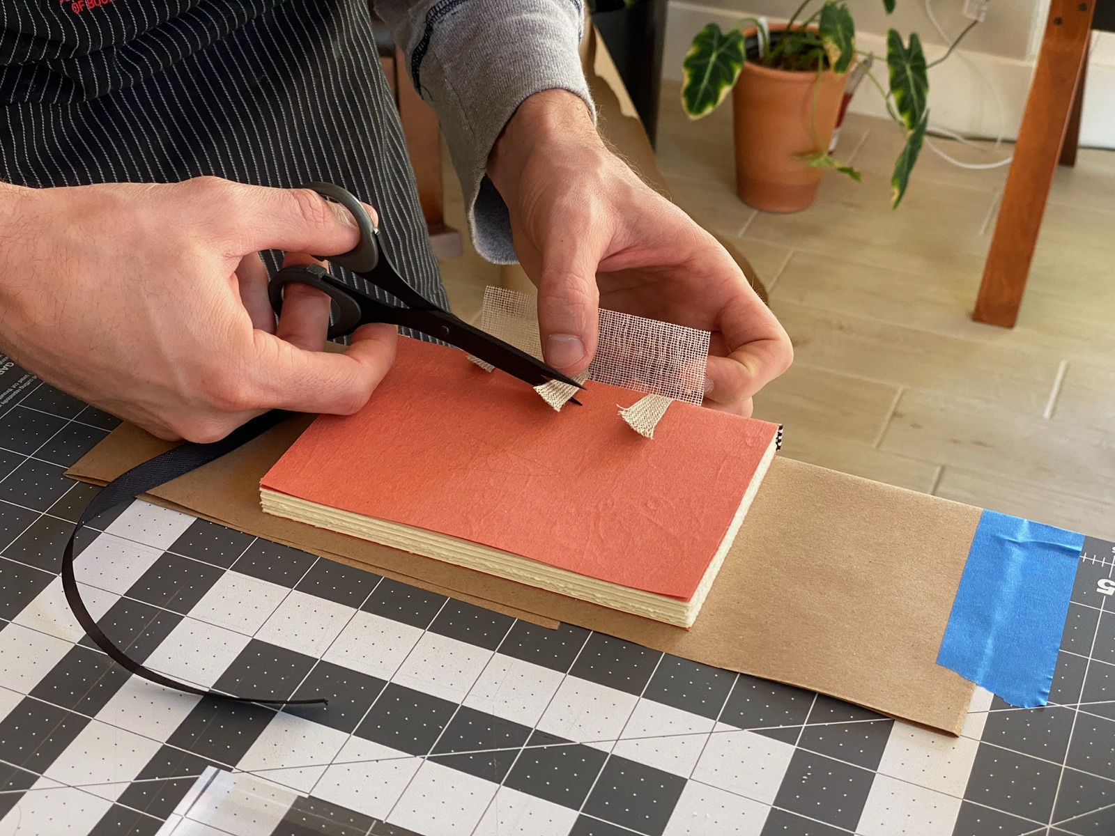 medium shot of person trimming cloth tape from a text block with scissors