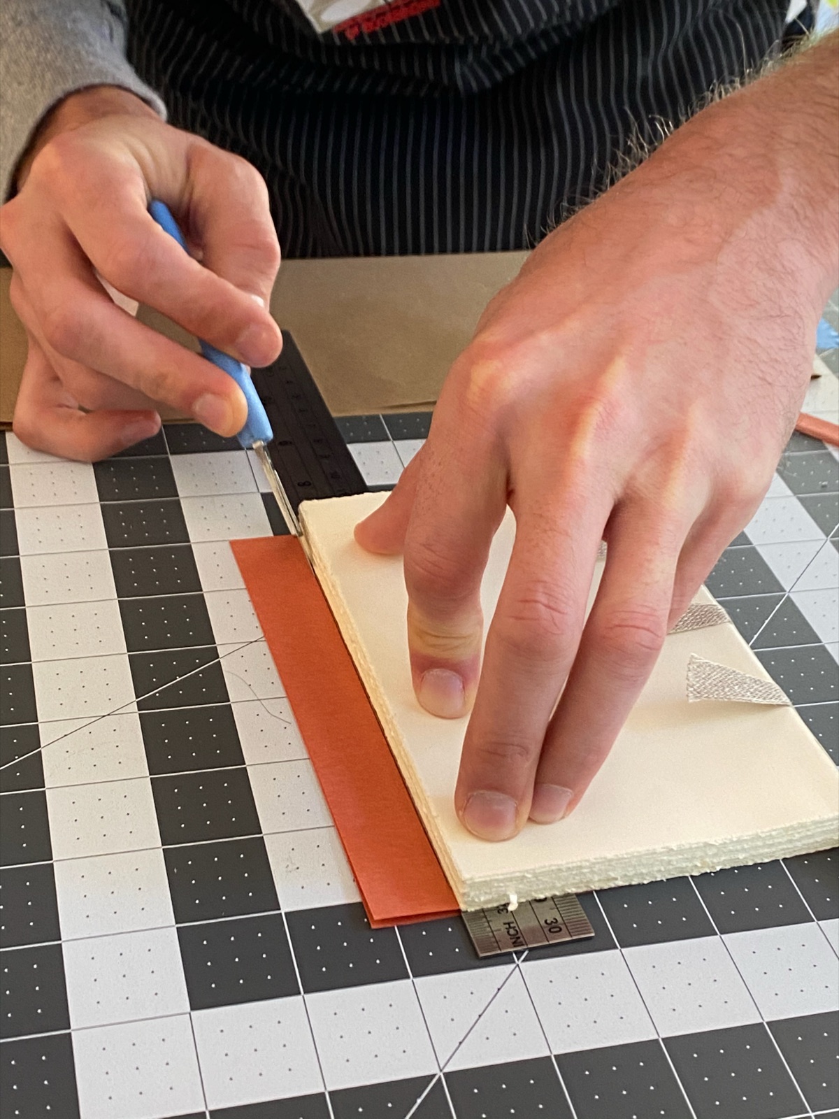 close up of a person trimming paper material for end sheets