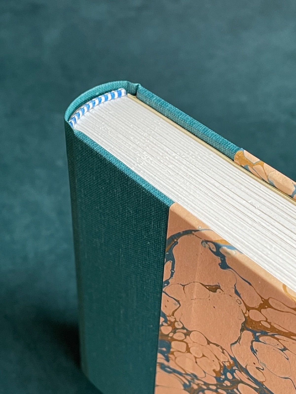 Spine and joint detail of the teal and marbled binding.
