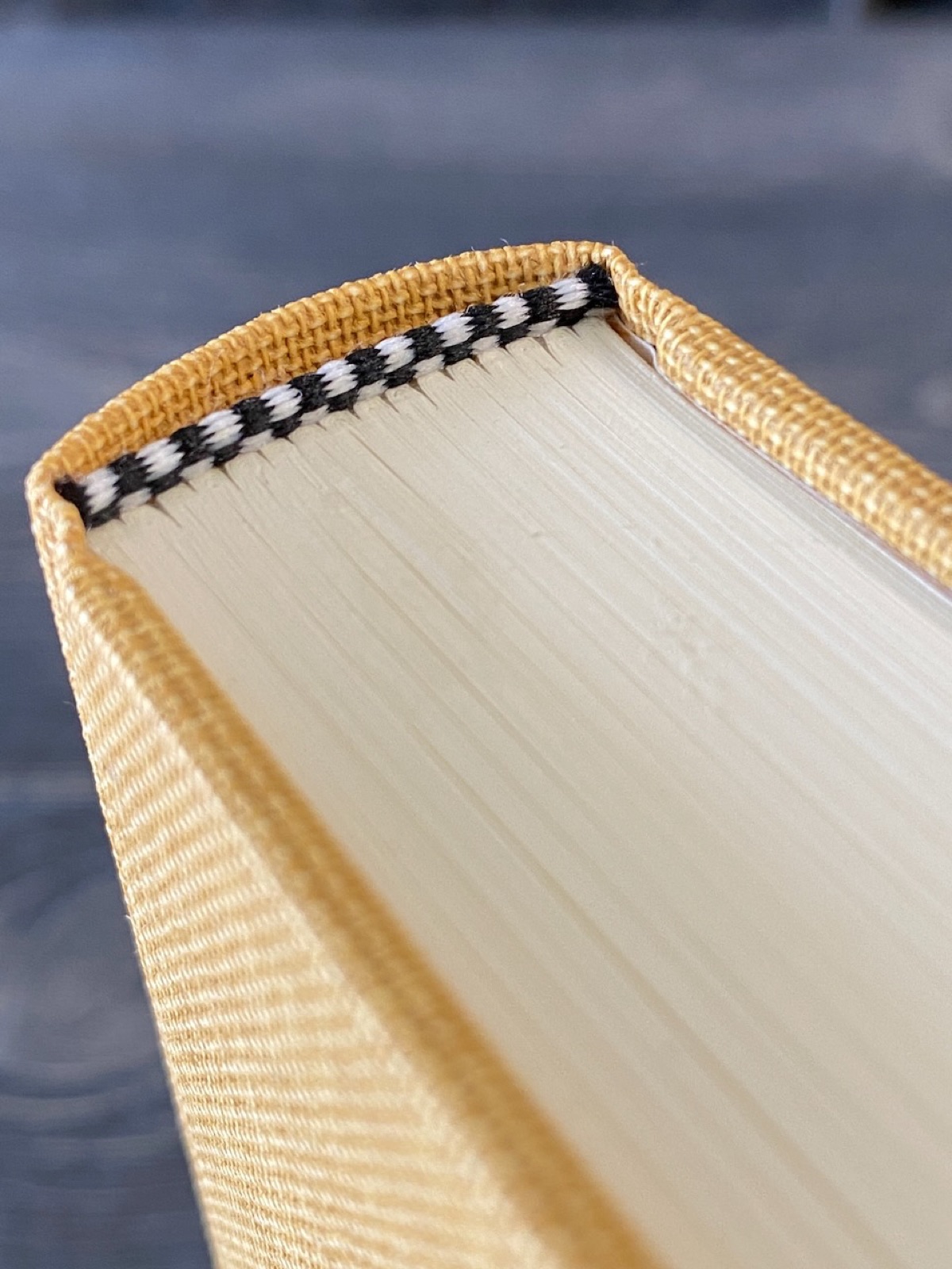 Detail of the sewn endband at the head of the yellow binding.