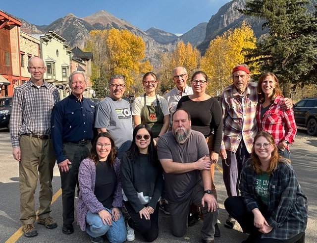 A bookbinding class group photo in front of Telluride’s mountains.