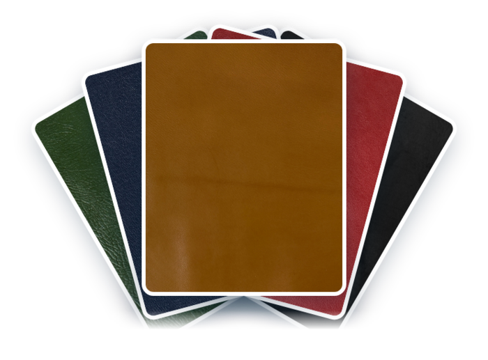 A sampling of bookbinding leathers in green, blue, whiskey, brown, ivory, maroon, black, and white.