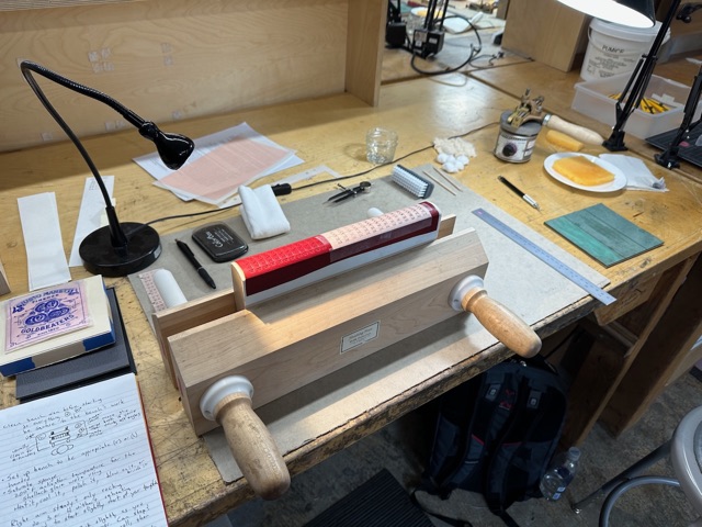 A titling workbench with finishing press, tools, and lamp at North Bennet Street School.