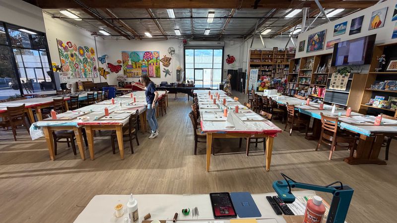 The Art Trek classroom set up for the workshop, each place laid with tools and materials.